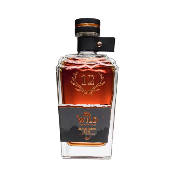 Eine Flasche Black Wood Rum mit klarem Glasdesign, Kupferakzenten und einem dunklen Etikett mit Geweih und Berggrafiken.