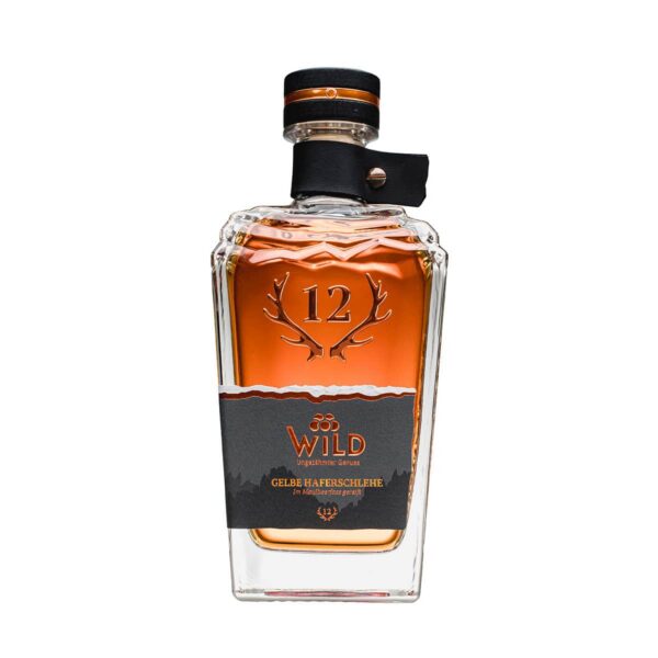 Eine Klarglasflasche mit Gelbe Haferschlehe Maulbeerfass Likör mit bernsteinfarbener Flüssigkeit, Geweihmotiv und einem schwarz-orangefarbenen Siegel am Hals.