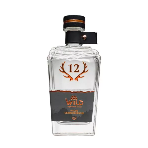Eine Klarglasflasche mit der Aufschrift Wilde Gebirgskirsche mit Geweihgrafik, einem schwarz-kupferfarbenen Verschluss und einem grauen Etikett. Die Flasche enthält eine klare Flüssigkeit.