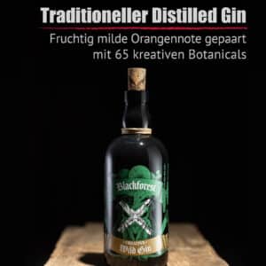 Eine Flasche Blackforest Wild Gin Creative mit Korkverschluss und grünem Etikett, dargestellt auf einer hölzernen Oberfläche vor einem schwarzen Hintergrund.