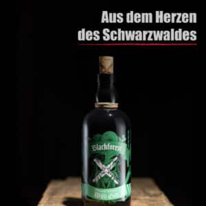 Eine Flasche Blackforest Wild Gin Traditional steht auf einer hölzernen Fläche mit dem deutschen Text "Aus dem Herzen des Schwarzwaldes" darüber.