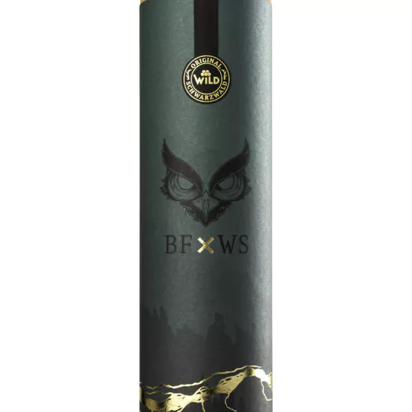 Die Geschenkdose Blackforest Wild Spirits ist ein zylindrischer grüner Behälter mit Korkdeckel, stilisierter Eulengrafik, goldenem Siegel und den Buchstaben BF x WS auf der Vorderseite.