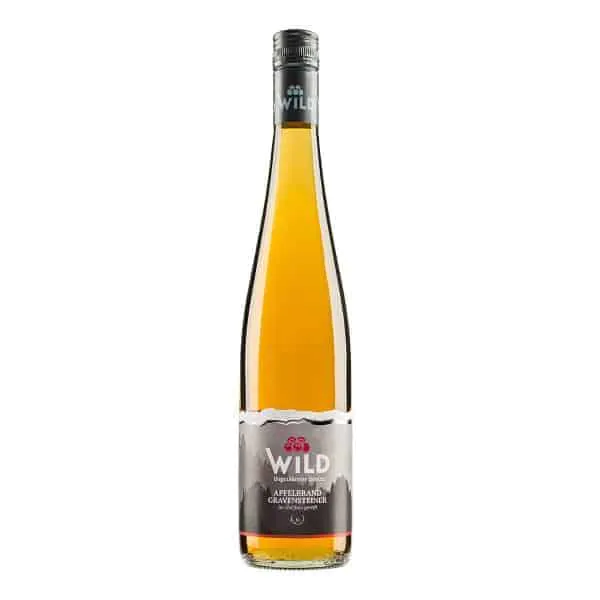 Hohe Glasflasche mit bernsteinfarbener Flüssigkeit, mit der Aufschrift Wild Apfelbrand Gravensteiner, einem Schraubverschluss und einer dezenten Berggrafik auf dem Etikett.