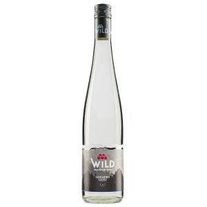 Eine Klarglasflasche des Obstbrandes der Marke Wild mit der Aufschrift "Schlehen Geist", mit einem silbernen Verschluss und einem grauen Etikett mit Berggrafik.