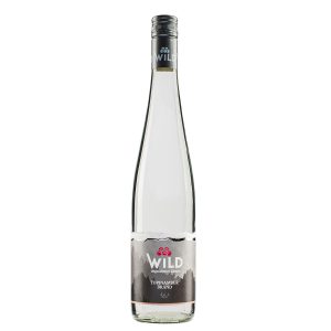 Eine Klarglasflasche der Spirituose Topinambur der Marke Wild mit einem silbernen Verschluss und einem Etikett mit Bergmotiven.