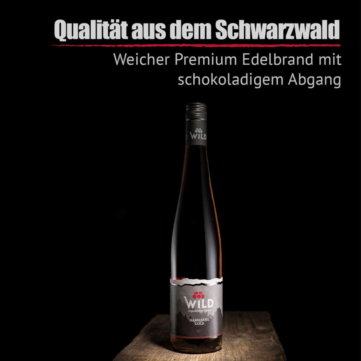 Auf einer Holzplatte steht eine Flasche Haselnuss-Gold, über der ein deutscher Text steht, der den Likör als sanften Premium-Haselnusslikör mit schokoladigem Abgang aus dem Schwarzwald beschreibt.