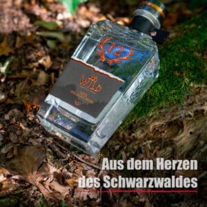 Eine Flasche Rote Williams-Birne ruht auf moosbewachsenem Boden und herabgefallenen Blättern, mit dem Text "Aus dem Herzen des Schwarzwaldes" in der unteren rechten Ecke.