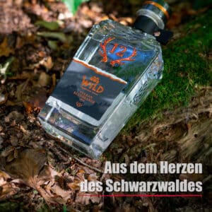 Eine Flasche Vulkan Blutorange Moro ruht auf Moos und Blättern im Freien, im Vordergrund steht der Text Aus dem Herzen des Schwarzwaldes.