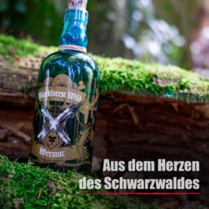 Eine Flasche Blackforest Wild Wermut steht auf moosbewachsenem Holz in einem Wald und trägt die Aufschrift "Aus dem Herzen des Schwarzwaldes".