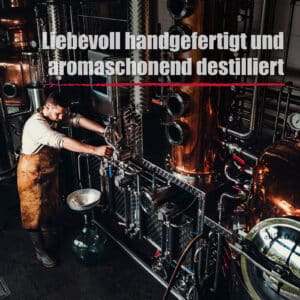 Ein Mann in einer Schürze bedient eine Destillationsmaschine in einer Industrieanlage; der deutsche Text lautet "In liebevoller Handarbeit und schonend destilliert" für Wilde Vogelbeere.