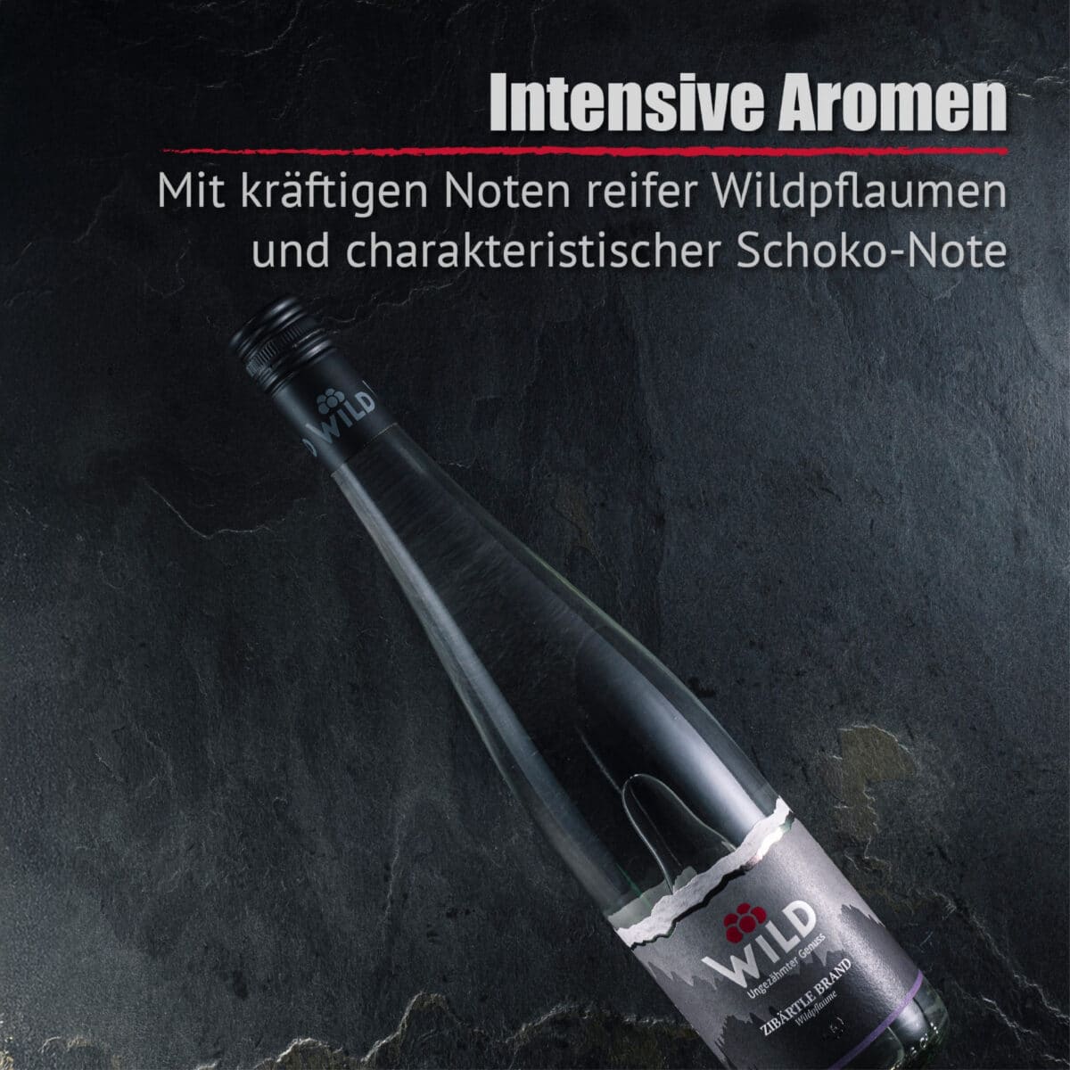 Eine Flasche Zibärtle Wildpflaumenbrand ruht auf einer dunklen Steinfläche. Der deutsche Text hebt die intensiven Aromen reifer Wildpflaumen und die ausgeprägten Schokoladennoten hervor.