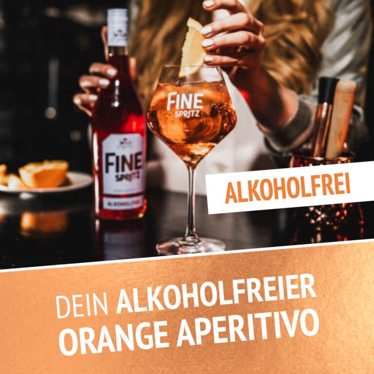 Eine Person hรคlt ein Glas Orange FINE Spritz - Alkoholfrei 0,7l mit einer Orangenscheibe; die Flasche steht auf dem Tisch. Der Text lautet: Alkoholfrei und Dein alkoholfreier Orange Aperitivo.