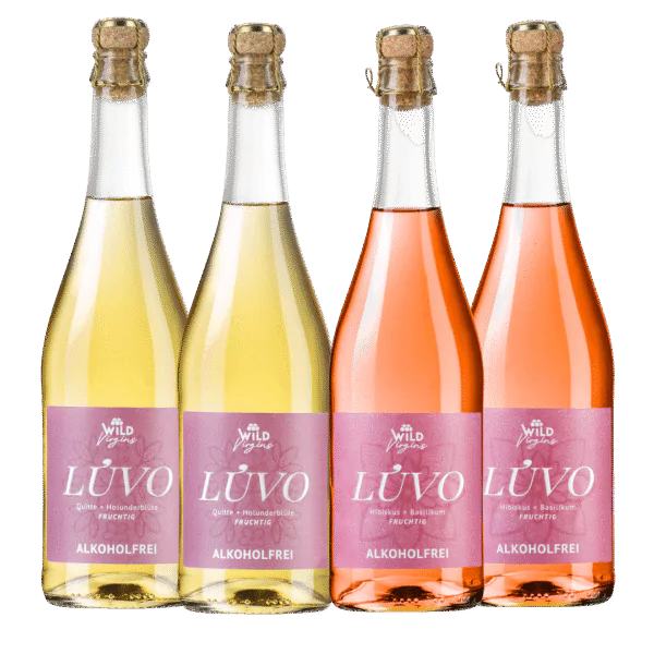 Vier Flaschen aus dem LÚVO Pink Label Probierbundle: zwei mit gelber Flüssigkeit und zwei mit rosafarbener Flüssigkeit, jeweils mit rosafarbenen Etiketten und Korkverschlüssen.