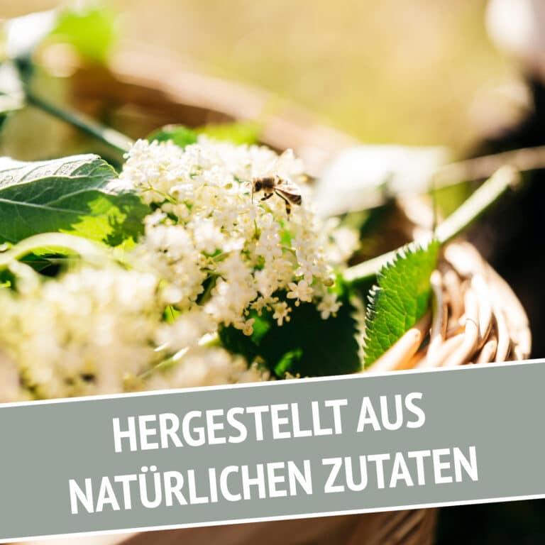 Eine Nahaufnahme von Holunderblüten und grünen Blättern in einem Korb, mit einer Biene auf den Blüten. Text überlagert: LÚVO Quitte x Holunderblüte - Alkoholfrei. Hergestellt aus natürlichen Zutaten. Perfekt für einen alkoholfreien Spritz.