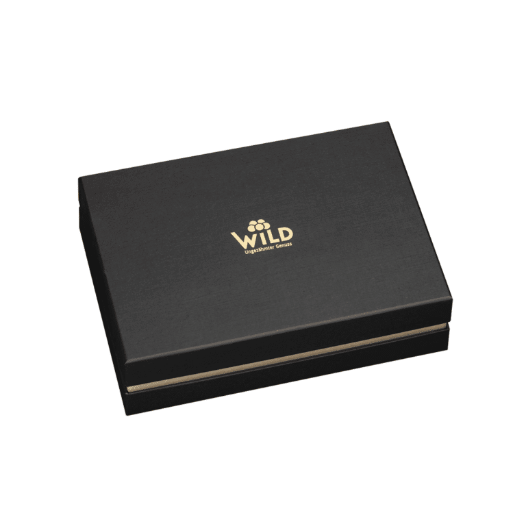 Die Premium Blackforest Wild Spirits Tastingbox ist eine geschlossene, schwarze, rechteckige Geschenkbox mit dem Schriftzug WILD" und einem goldenen Blumenlogo auf dem Deckel vor weißem Hintergrund - ideal, um ein einzigartiges Verkostungserlebnis zu teilen.